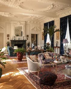 a living room filled with lots of furniture and decor on top of hard wood floors