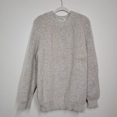 a gray sweater hanging on a white wall