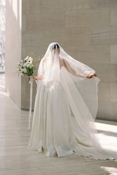 a woman in a white wedding dress and veil