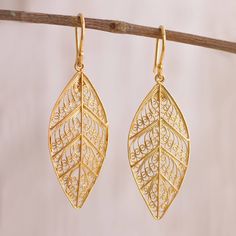 This bright and mysterious pair of dangle earrings from Peru is designed by Nancy Quispe. Working with her husband she handcrafts two dazzling leaves from sterling silver with a 24k gold plating featuring intricate filigree openwork. The magnificent earrings dangle from hooks. Filigree Hoop Earrings, Gold Filigree Earrings, Filigree Jewelry, Gold Pendant Jewelry, Jewelry Showcases, Filigree Earrings, Bridal Gold Jewellery Designs, Sterling Silver Filigree, Gold Filigree