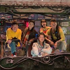 a group of people posing for a photo in front of a space station with lights on