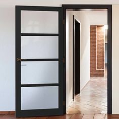 an open door leading to a hallway with brick walls and tile flooring on either side