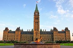 a large building with a clock tower in the middle of it's front yard