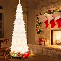 a white christmas tree sitting in front of a fireplace