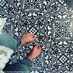 a person standing on top of a black and white floor next to a flower pattern