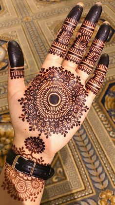 a woman's hand with henna tattoos on it