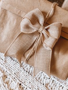 a brown wrapped present sitting on top of a white blanket