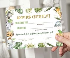 a person holding up a certificate for an animal themed baby shower or birthday party with animals on it