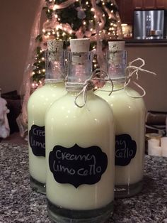 three candles sitting on top of a counter next to a christmas tree