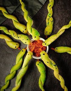 some strange looking food items in a bowl on a black tablecloth with green stems