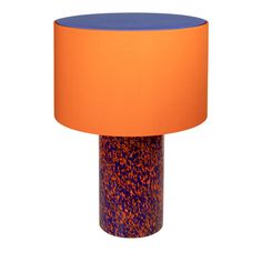 an orange and blue table lamp on a white background with a purple shade over it