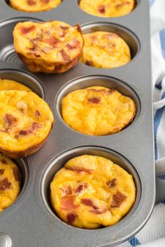 several muffins in a pan with bacon on top