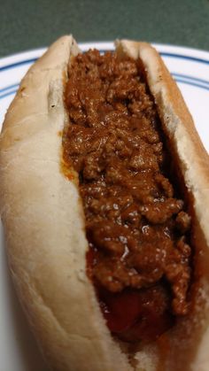 a chili dog sitting on top of a white plate