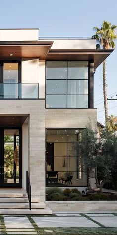 a modern house with large windows and steps leading up to the front door