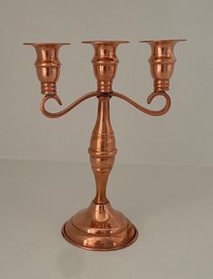 a copper candelabra with three candles on it