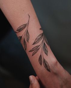 a woman's arm with leaves on it