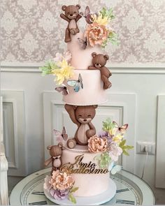 a three tiered cake decorated with teddy bears and flowers