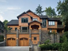 a large wooden house with two garages