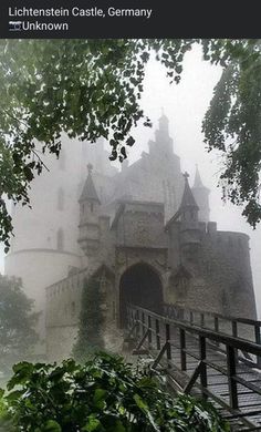 an old castle in the fog with stairs leading up to it