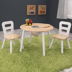 a child's table and two chairs in a room with rugs on the floor