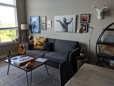 a living room filled with furniture and pictures on the wall above it's windows