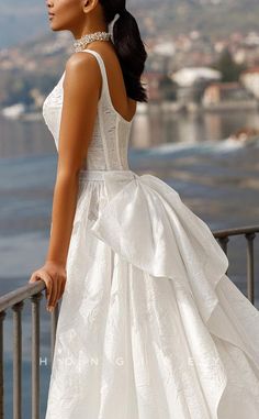 a woman in a white dress standing on a balcony