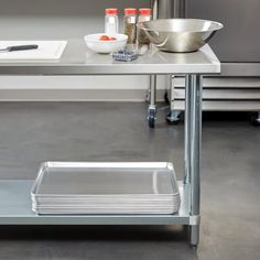 a stainless steel table with two trays on each side and one empty plate on the other