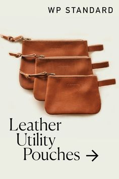 three leather utility pouches with zippers on the front and side, all lined up together