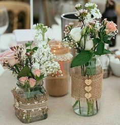 three vases with flowers are sitting on a table