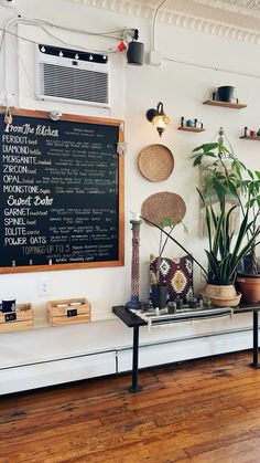 there is a menu on the wall next to some potted plants and other items