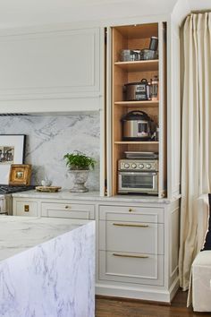 a kitchen with marble counter tops and white cabinets