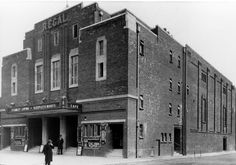 an old black and white photo of people standing in front of a building