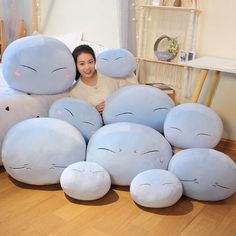 a woman is sitting on the floor surrounded by giant pillows that are shaped like animals