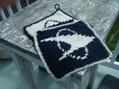 a crocheted blue and white blanket sitting on top of a wooden table next to a chair