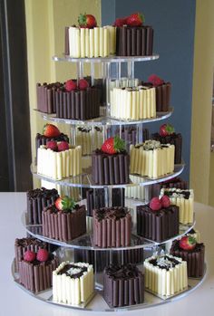 a tiered cake with chocolate and white frosting on it, topped with strawberries