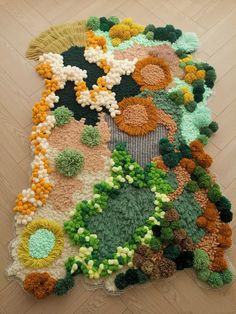 the rug is made with crocheted flowers and leaves on top of wood flooring