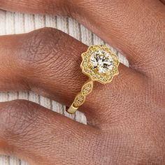 a woman's hand with a yellow diamond ring on her left hand and the other hand holding it