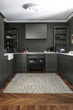 a kitchen with gray cabinets and white counter tops is shown in this image, there is a rug on the floor