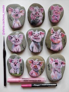 six painted rocks with pig faces on them and a pink marker next to the rocks