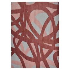 a pink and blue rug with an abstract design on the bottom, in front of a white background