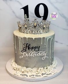 a birthday cake decorated with silver icing and a tiara on top that says happy 10th birthday