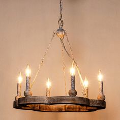 a chandelier made out of an old barrel with candles hanging from the bottom