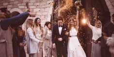 a group of people standing in front of a building with confetti thrown on them