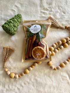 an assortment of fruits and vegetables are laid out on a white blanket next to a wooden bead necklace