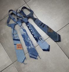 four pairs of jeans are laid out on the floor, with ties attached to them