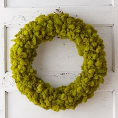 a moss wreath hanging on the front door