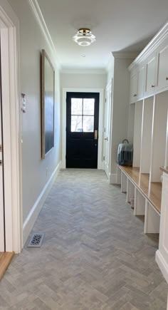 an empty hallway with white cabinets and wood flooring