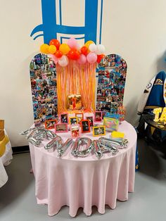 a table with balloons and pictures on it