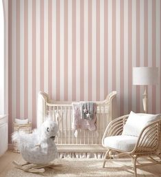 a baby's room with pink and white striped wallpaper, rocking chair and crib