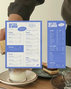 the menu is being held up by someone's legs on a table with plates and cups